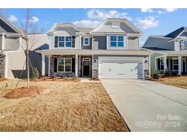 Two-story house with gray siding, stone accents, and a white door at 5312 Verona Rd # 74, Charlotte, NC 28213