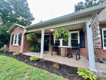 Charming front porch with rocking chairs and hanging plants at 469 Radio Rd, Taylorsville, NC 28681