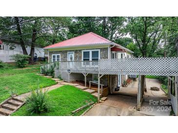 Stone house with red metal roof, deck, and carport at 93 13Th Se St, Hickory, NC 28602