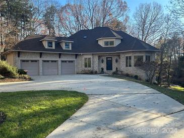 Stone and shingle exterior boasts a three-car garage and ample driveway at 301 Agnew Rd, Mooresville, NC 28117