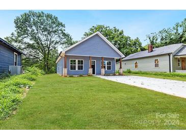 Newly built home with blue siding, concrete driveway, and grassy yard at 1332 Caldwell St, Statesville, NC 28677