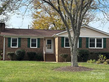 Brick ranch house with green shutters, steps to the front door, and a spacious lawn at 634 Lancer Ct, Concord, NC 28027