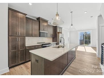 Modern kitchen with island, stainless steel appliances, and dark cabinetry at 1432 Hamilton St # 14, Charlotte, NC 28206