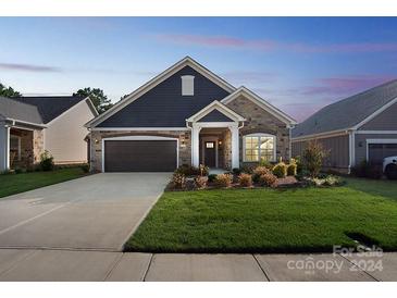 Craftsman style home with stone and siding, two-car garage, and landscaped lawn at 1346 Millview Ln, Matthews, NC 28104