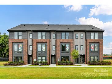 Three-story townhouses with brick and siding at 3018 Khan Park Dr # 66, Charlotte, NC 28206