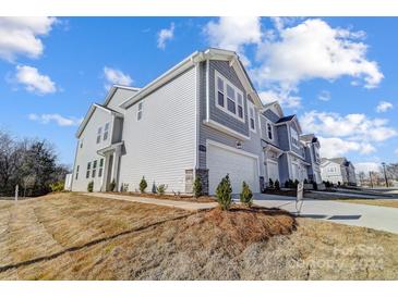 Two-story townhome with gray siding, two-car garage, and landscaping at 6210 Vasey St, Charlotte, NC 28269