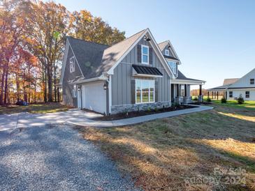 Gray farmhouse exterior with stone accents, covered porch, and attached garage at 4117 Parkwood School Rd # Lot 2, Monroe, NC 28112