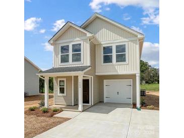 Two-story house with beige siding, attached garage, and front porch at 502 Elpine St, Statesville, NC 28677