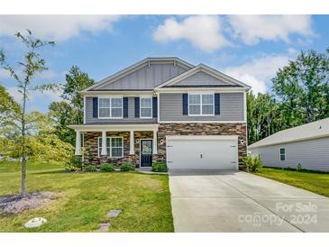 Two-story house with gray siding and stone accents at 208 Wildflower Dr, Locust, NC 28097