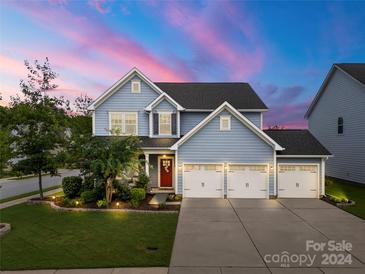 Two-story house with gray siding, three-car garage, and landscaping at 305 Redberry Ct, York, SC 29745