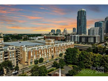 Aerial view of a modern building with city skyline in background at 710 W Trade St # 320, Charlotte, NC 28202