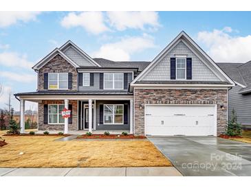 Two-story home with stone and shingle accents, a three-car garage, and a covered porch at 8731 Acadia Pkwy # 615, Sherrills Ford, NC 28673