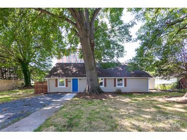 Updated bungalow with a charming blue door and large shade tree at 307 S Ransom St, Gastonia, NC 28052