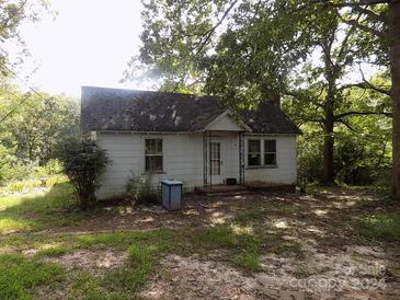 White single story home with mature trees surrounding at 719 Mauney Rd, Stanley, NC 28164