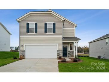 Two-story house with taupe siding, dark door, and driveway at 744 Olde England Dr, Lincolnton, NC 28092