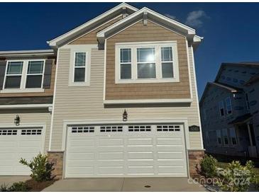 Beige and brown two-story townhouse with a two-car garage at 6341 Mallow Crossing Lane Ln, Charlotte, NC 28213