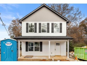 Charming two-story home with white siding, black shutters, and a covered front porch at 9251 Misenheimer Rd, Charlotte, NC 28215