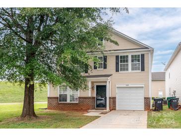 Two-story home with beige siding, brick accents, and attached garage at 8432 Panglemont Dr, Charlotte, NC 28269