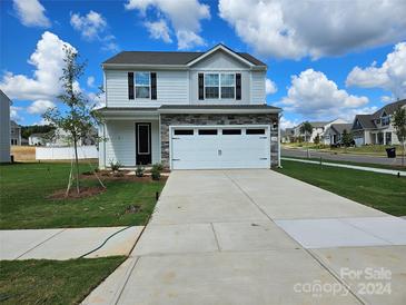 Two-story house with stone accents, two-car garage, and landscaped lawn at 118 Brixham Loop, Troutman, NC 28166