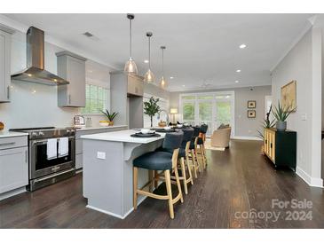 Modern kitchen with gray cabinets, island with seating, and dark hardwood floors at 1412 W 4Th St, Charlotte, NC 28208