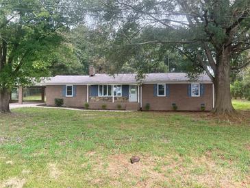 Ranch home with brick facade and mature landscaping at 201 Rocky River Rd, Oakboro, NC 28129