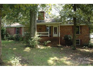 Brick ranch house with front porch and landscaping at 8202 & 8204 Carriker Williams Rd, Fairview, NC 28110