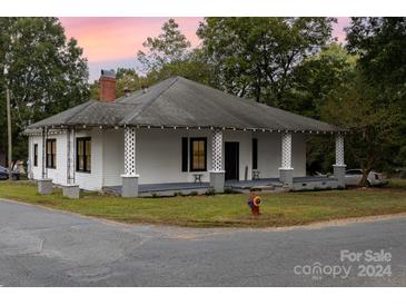 Charming white house with a front porch and landscaping at 601 Hasty St, Marshville, NC 28103