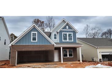 Two-story home with brick and siding exterior, attached garage, and welcoming front porch at 143 Ella Claire Dr # 004, York, SC 29745