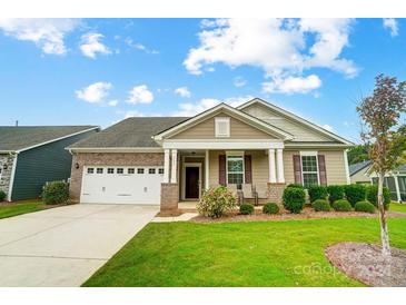 Two-story home with a two-car garage, manicured lawn, and covered porch at 731 Wood Lily Dr, Belmont, NC 28012