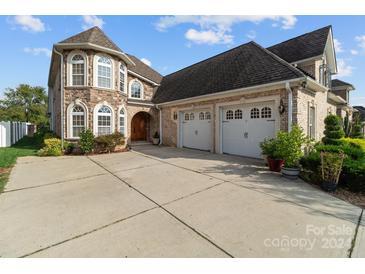 Stone and brick home exterior with a two-car garage and landscaping at 4532 Lanstone Sw Ct, Concord, NC 28027