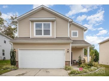 Tan two-story house with a two-car garage and well-maintained landscaping at 12009 Downy Birch Rd, Charlotte, NC 28227