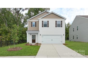 Two-story house with a beige exterior, two-car garage, and landscaped lawn at 3694 Charles Nw St, Conover, NC 28613