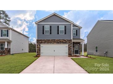 Two-story home with gray siding, stone accents, and a two-car garage at 14236 Wilson Mac Ln, Charlotte, NC 28278