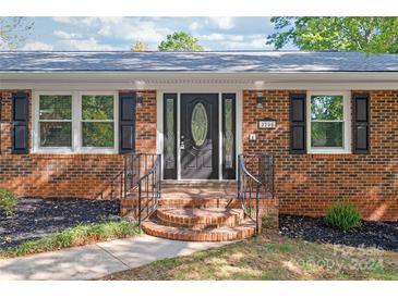 Brick ranch house with a black front door and landscaping at 2200 Quail Nw Dr, Concord, NC 28027