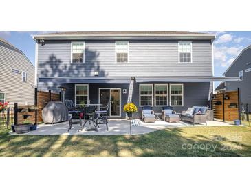 Home's back view with patio, awning, and yard at 126 Walleye Ln, Troutman, NC 28166