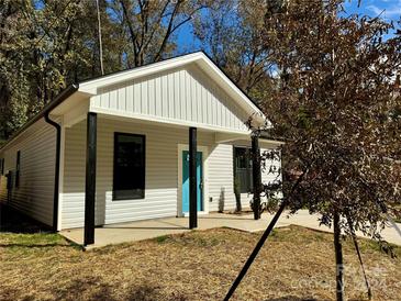 Newly constructed home with gray siding, a teal door, and a covered porch at 1712 Mcdonald St, Charlotte, NC 28216