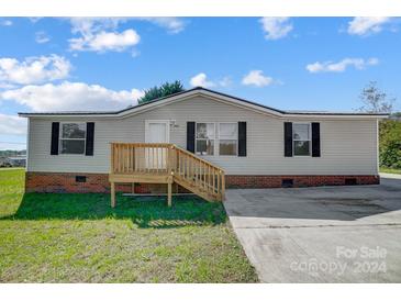 Front view of a manufactured home with brick skirt and deck at 1363 Shinnville Rd, Cleveland, NC 27013