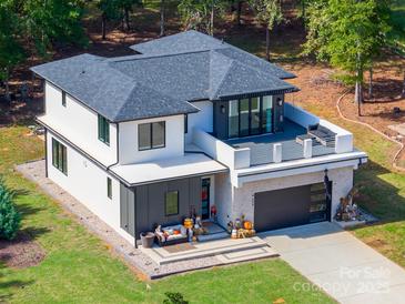 Modern two-story home with a deck and two-car garage, nestled in a wooded area at 4608 Rockwood Dr, Waxhaw, NC 28173