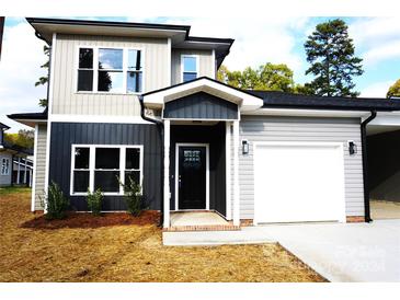 Two-story home with gray and beige siding, black door, and attached garage at 1024 W C St, Kannapolis, NC 28081