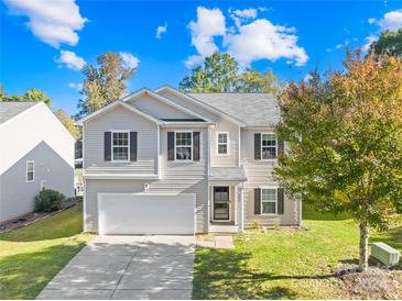 Two-story house with neutral siding, attached garage, and landscaped yard at 1231 Lauren Village Dr, Charlotte, NC 28213