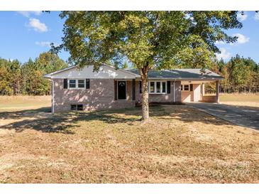 Brick ranch house with a covered carport and large tree in front at 1251 Magnolia St, Albemarle, NC 28001