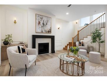 Bright living room features a fireplace, hardwood floors, and stylish furniture at 1401 Meadow Ln, Charlotte, NC 28205