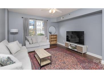 Living room with light sofa, coffee table, and large TV at 1315 East Blvd # 408, Charlotte, NC 28203