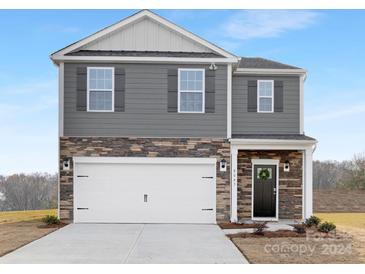 Charming two-story home with a gray and stone facade, white garage door, and inviting front porch at 8063 Plymouth Dr, Sherrills Ford, NC 28673