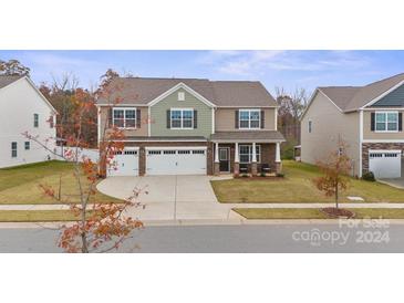 Two-story house with a two-car garage, stone accents, and a covered porch at 7805 Stonehouse Dr, Gastonia, NC 28056