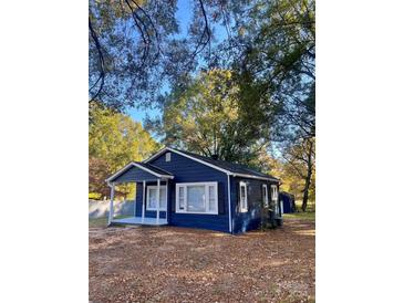 Charming blue house with mature trees and a well-maintained yard at 2123 W 6Th Ave, Gastonia, NC 28052