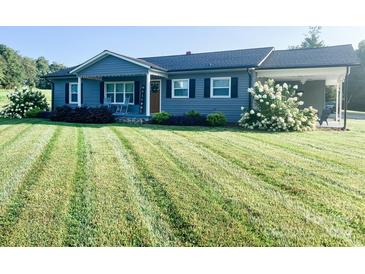 Gray house with a white porch and rocking chairs, landscaped yard at 2400 Black Oak Ridge Rd, Taylorsville, NC 28681