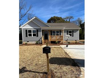 Newly constructed gray house with a front porch and landscaped yard at 1327 Old Salisbury Rd, Statesville, NC 28625