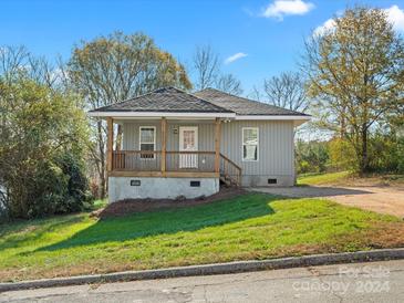 Newly constructed home with gray siding, a covered porch, and a well-maintained lawn at 306 Flat Rock St, Clover, SC 29710