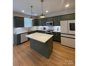 Modern kitchen with dark green cabinets, quartz countertops, and island at 320 Lawrence Gray Rd, Charlotte, NC 28262